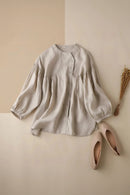 Beige blouse with puffed sleeves on a beige background with shoes and dried plants, Obroi