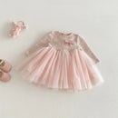 Pink children's dress with a bow on a light gray background, Obroi