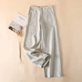 Light gray pants on a beige background with a magazine and decorative items, Obroi