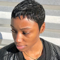 Woman with a short black hairstyle wearing a black jacket against a striped background, Obroi
