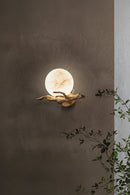 Wall-mounted light fixture with decorative branch on a textured , Obroi