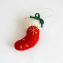 Red and white Christmas stocking ornament with gold snowflake design on a white , Obroi.