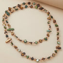 Necklace with natural stones and pearls on a beige background, Obroi