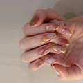 Close-up of hands with pink and gold nail polish on a neutral background, Obroi