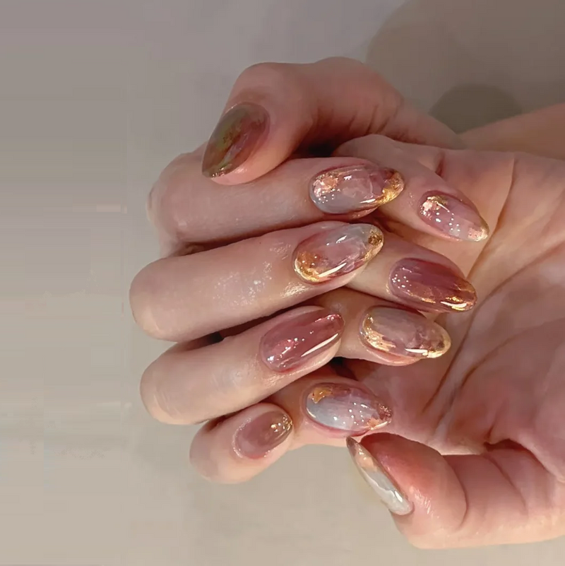 Close-up of hands with pink and gold nail polish on a neutral background, Obroi