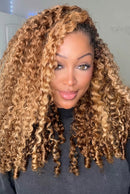 Woman with curly blonde hair wearing a dark gray top indoors, Obroi