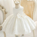 White lace dress with a large bow on a mannequin against a decorative background, Obroi