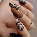Hand with intricately designed nails featuring brown, black, and white patterns on a neutral background ,Obroi