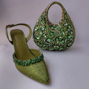Green high-heeled shoe and handbag with gemstone embellishments on a light gray background, Obroi