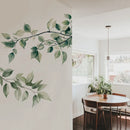 Dining room with a wall decal of green leaves and branches, Obroi