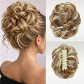 A blonde and brown synthetic updo hairpiece shown worn on a model's head from the back, plus two close-up views of the hairpiece itself on a light background. The hairpiece has a cream-colored claw clip closure, Obroi