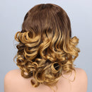 A shoulder-length wavy wig with a dark brown root and warm golden blonde ombré highlights, styled with soft curls, shown from the back on a mannequin head against a light gray background, Obroi
