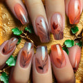 Nails with autumn-themed design featuring leaves and feathers on a decorative , Obroi.
