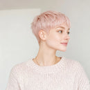 Woman with short pink hair wearing a light pink sweater against a plain background, Obroi