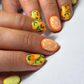 Nails with citrus-themed design on a white background, Obroi