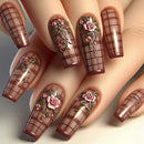 Nails with floral and grid designs on a neutral background, Obroi