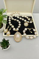 Jewelry set including necklace, earrings, and bracelet in a box with plants in the background, Obroi