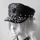 Black leather cap with skull and leopard print visor on a mannequin head against a white background, Obroi