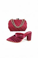 Red studded handbag and high-heeled shoes on a white background, Obroi