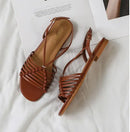 Pair of brown sandals on a white surface, Obroi