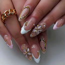 Close-up of hands with decorative nails featuring gold and white designs, Obroi