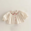 White blouse with red embroidery and buttons on a light gray background, Obroi