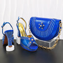 Blue high-heeled shoes and matching handbag with decorative elements on a black surface, Obroi