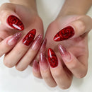 Close-up of hands with red floral nail art on a white background, Obroi
