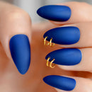 Blue nail polish on a hand with gold rings against a blurred background, Obroi