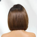 A woman viewed from the back wearing a short, straight bob wig with a dark brown root and warm medium brown highlights, against a plain white background, Obroi