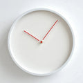 A minimalist round wall clock with a white frame and white dial, featuring thin red hands and a small red center dot. The brand name 'Obroi' is printed in small gold letters near the top center, Obroi