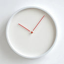 A minimalist round wall clock with a white frame and white dial, featuring thin red hands and a small red center dot. The brand name 'Obroi' is printed in small gold letters near the top center, Obroi