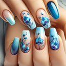 Nails with blue floral design on a hand, Obroi