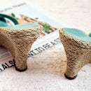 Two small stools with rope-like legs on a surface with text underneath, Obroi