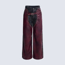 Maroon leather pants with black denim accents on a light gray background