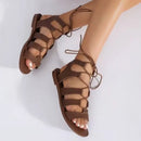 Brown strappy sandals worn by a person on a light gray background, Obroi