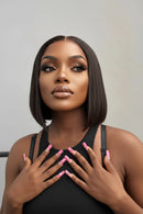 Woman with a stylish haircut and pink nail polish against a neutral background, Obroi