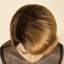 A Obroi 100% human hair wig displayed on a mannequin head, featuring a dark brown to golden blonde ombré color scheme with a side-swept bang. The brand logo 'Obroi 100% HUMAN HAIR' is visible in the top left corner.