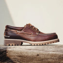 Brown leather boat shoe on a wooden surface with a neutral background, Obroi
