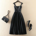 Black leather dress with matching handbag and high heels on a beige background, Obroi