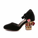 Black velvet shoe with decorative heel featuring flowers on a white background, Obroi