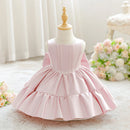 A light pink sleeveless dress for young children displayed on a cream dress form mannequin. The dress features a structured, corset-style bodice with a square neckline and a tiered ruffled skirt, Obroi