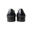Black crocodile-patterned shoes on a white background