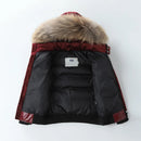 A black puffer jacket with a large brown faux-fur trimmed hood, featuring a deep burgundy collar and sleeve accents, laid flat against a white background, Obroi