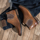 Brown leather boots with a brand tag on a wooden floor ,Obroi
