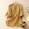 Mustard yellow blouse with lace details on a beige surface, accompanied by shoes and a handbag, Obroi