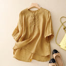Mustard yellow blouse with lace details on a beige surface, accompanied by shoes and a handbag, Obroi