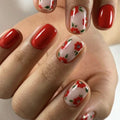 Nails with red and white floral design on a neutral background, Obroi