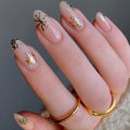 Nails with gold floral designs on a neutral background, Obroi