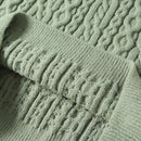 Close-up of a green knitted sweater with cable pattern, Obroi